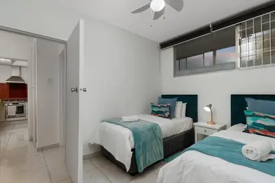 a bedroom with two beds and a window at Seaside Sunsets in Strand