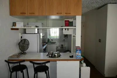 a kitchen with a white refrigerator and a table with chairs at Bradclin @ York in Cape Town