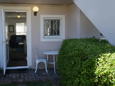 a table and chair sitting on the porch of a house at Bradclin @ York in Cape Town