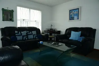 a living room with two leather chairs and a coffee table at Bradclin @ York in Cape Town