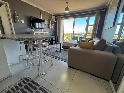 a kitchen and living room with a table and a couch at #FiftySeven in Hermanus