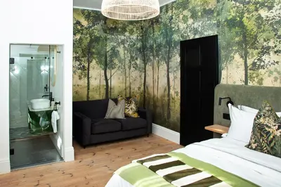 a bedroom with a bed and a couch at Paarl Hideaway in Paarl