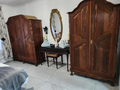 a bedroom with a large wooden wardrobe and a table with a mirror at Cape Town gem 
