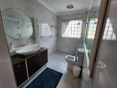 a bathroom with a sink toilet and a mirror at Cape Town gem 