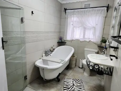 a bathroom with a tub and a toilet and a sink at Cape Town gem 