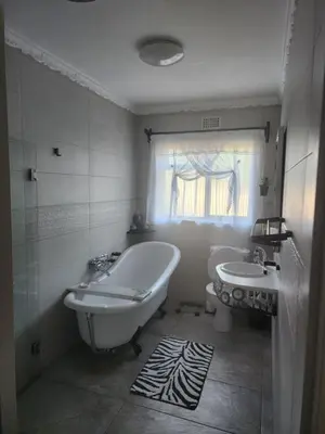 a white bathroom with a tub and a sink at Cape Town gem 