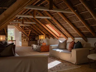 a living room with a white couch and wooden ceilings at The Doolhof Country House in Wellington