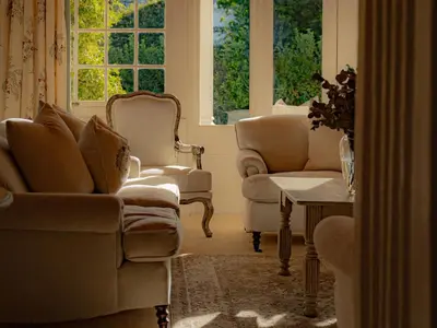 a living room with chairs and a table and windows at The Doolhof Country House in Wellington