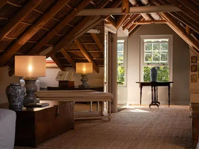 a living room with a table and a piano at The Doolhof Country House in Wellington