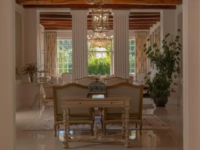 a dining room with a table and chairs and a chandelier at The Doolhof Country House in Wellington