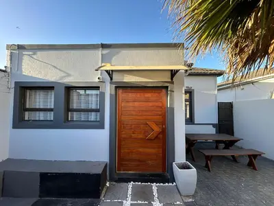 a house with a wooden door and a picnic table at 57onWYNNE in Cape Town