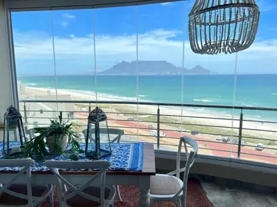 a dining room with a table and a view of the beach at Portico 705 in Cape Town