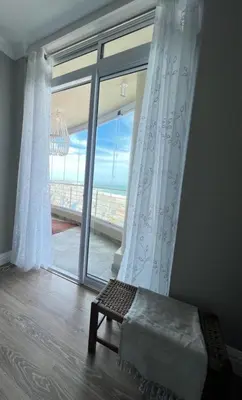 a bedroom with a large window with a view of the ocean at Portico 705 in Cape Town