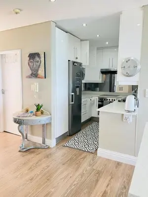 a kitchen with a refrigerator and a table in it at Portico 705 in Cape Town