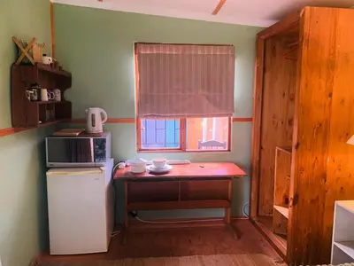 a small kitchen with a small table and a window at The Farmhouse Palm Tree Cabin in Stellenbosch