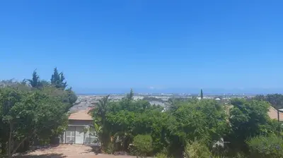 a house on a hill with trees in the foreground at Sophia’s Cottage in Cape Town
