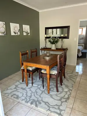 a dining room with a wooden table and chairs at Sophia’s Cottage in Cape Town