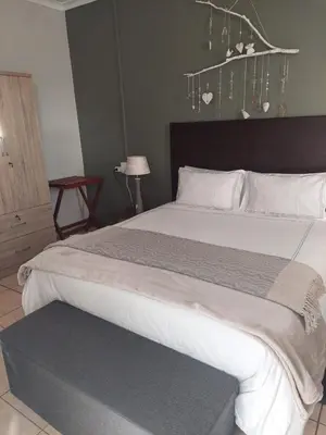 a bedroom with a large bed with a large white bed sidx sidx sidx at Sophia’s Cottage in Cape Town