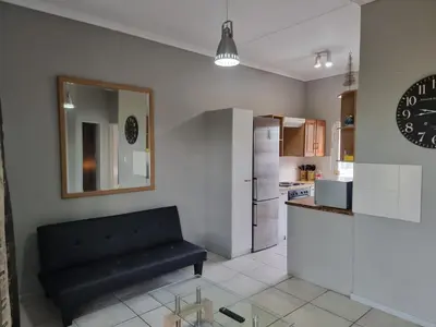 a kitchen with a black couch in a room at Strawberry fields Tranquility in Cape Town