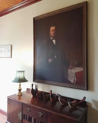 a painting of a man in a suit on a wall at Wildekrans Country House in Botrivier