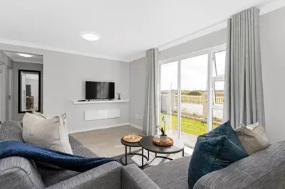 a living room with a couch and a tv at Elegant, Spotless 2 Bed For Enchanted Stays in Cape Town