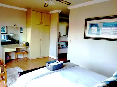 a bedroom with a bed and a desk in it at Casa Mia Guesthouse in Table View