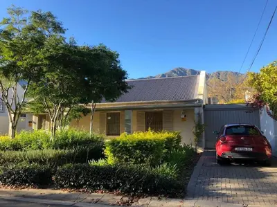 a red car parked in front of a house at Leopard Tree Cottage in Franschhoek