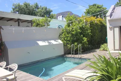 a swimming pool in the backyard of a house at Leopard Tree Cottage in Franschhoek