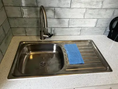 a kitchen sink with a blue towel in it at the Vine in Cape Town
