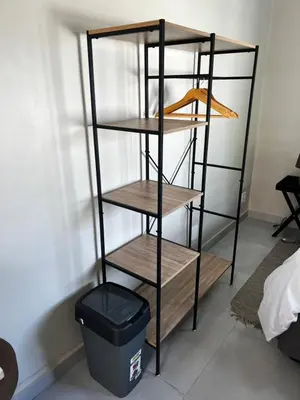 a shelf in a room with a trash can at the Vine in Cape Town