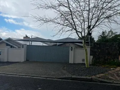 a white house with a fence and a tree at the Vine in Cape Town