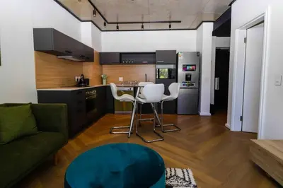 a kitchen and living room with a couch and a table at Modern apartment in Century City in Cape Town