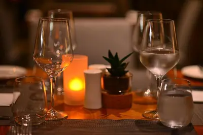 a table with three wine glasses and a candle at Belina - Crystal Towers Presidential Penthouse in Cape Town