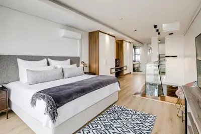 a bedroom with a large white bed and a glass room at Belina - Crystal Towers Presidential Penthouse in Cape Town