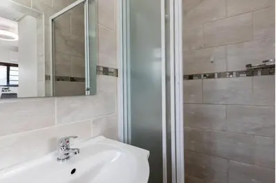 a bathroom with a sink and a shower at The Elephant Cottage in Cape Town