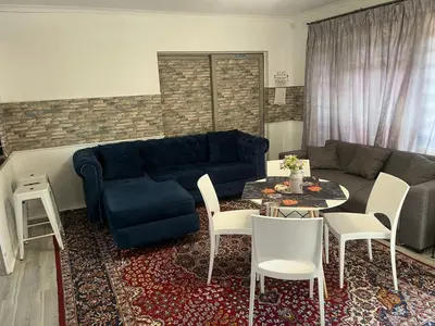 a living room with a blue couch and a table at The Elephant Cottage in Cape Town