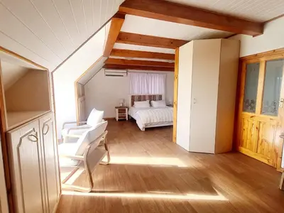 a room with a bedroom with a bed and chairs at Firlands Farmhouse 179A with a view in Sir Lowry Pass