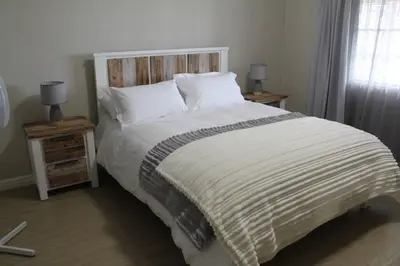 a bedroom with a large bed with two night stands at Firlands Farmhouse 179A with a view in Sir Lowry Pass