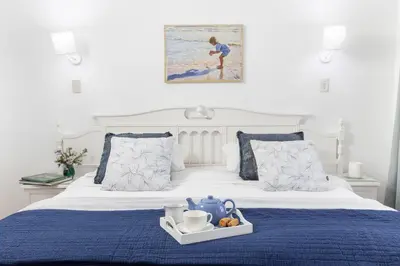 a bedroom with a bed with a blue bedspread at Casa Familia in Hermanus