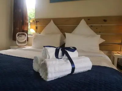 a bed with towels with a ribbon on it at Coastal Cozy 2 in Cape Town