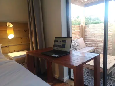 a laptop computer sitting on a wooden table in a bedroom at Coastal Cozy 2 in Cape Town