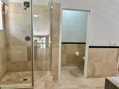 a shower with a glass door in a bathroom at Meerendahl Luxury Apartments at Tyger Lake in Cape Town