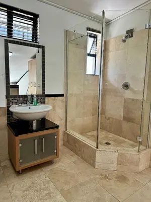 a bathroom with a sink and a shower at Meerendahl Luxury Apartments at Tyger Lake in Cape Town