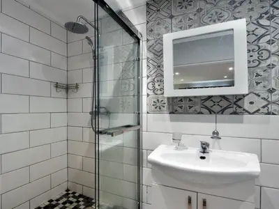 a bathroom with a sink and a glass shower at La Rochelle Cottage in Franschhoek