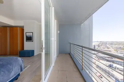 a bedroom with a balcony with a view of a city at Horizon Bay 1603 by HMH in Cape Town