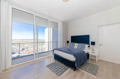 a bedroom with a bed and a large window at Horizon Bay 1603 by HMH in Cape Town