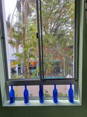 a window with blue vases sitting on a window sill at Amatoni green apartment in Stellenbosch