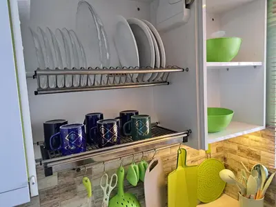 a kitchen with plates and utensils on a shelf at Amatoni green apartment in Stellenbosch