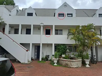 a white building with two red circles on it at Amatoni green apartment in Stellenbosch