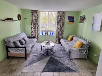 a living room with a couch and a table at Amatoni green apartment in Stellenbosch